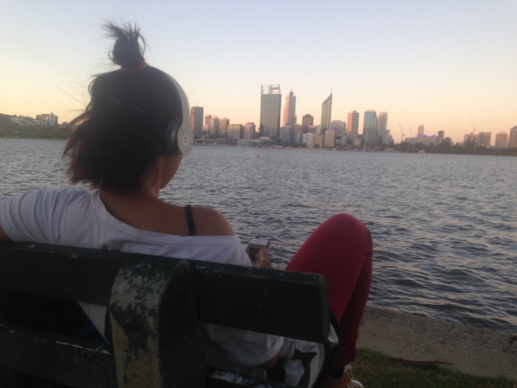 Sonia in un momento di relax, musica nelle orecchie e lo skyline di Perth sullo sfondo